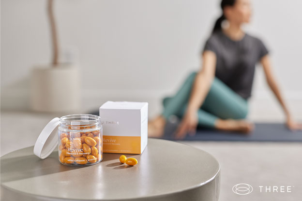 a woman doing yoga with a bottle of revíve supplements shown in the foreground